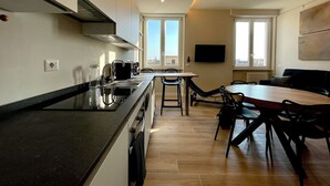 A modern kitchen with a central island, a dining area with a table and chairs, and a large window providing a view of the city. - Your home in Rome

4 Rooms & 4 Elements 

Spacious penthouse for 12 guests
 (Roma)