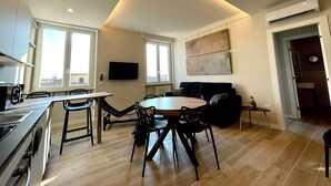 A modern kitchen with a dining area, a flat-screen TV, and a large window. - Your home in Rome

4 Rooms & 4 Elements 

Spacious penthouse for 12 guests
 (Roma)