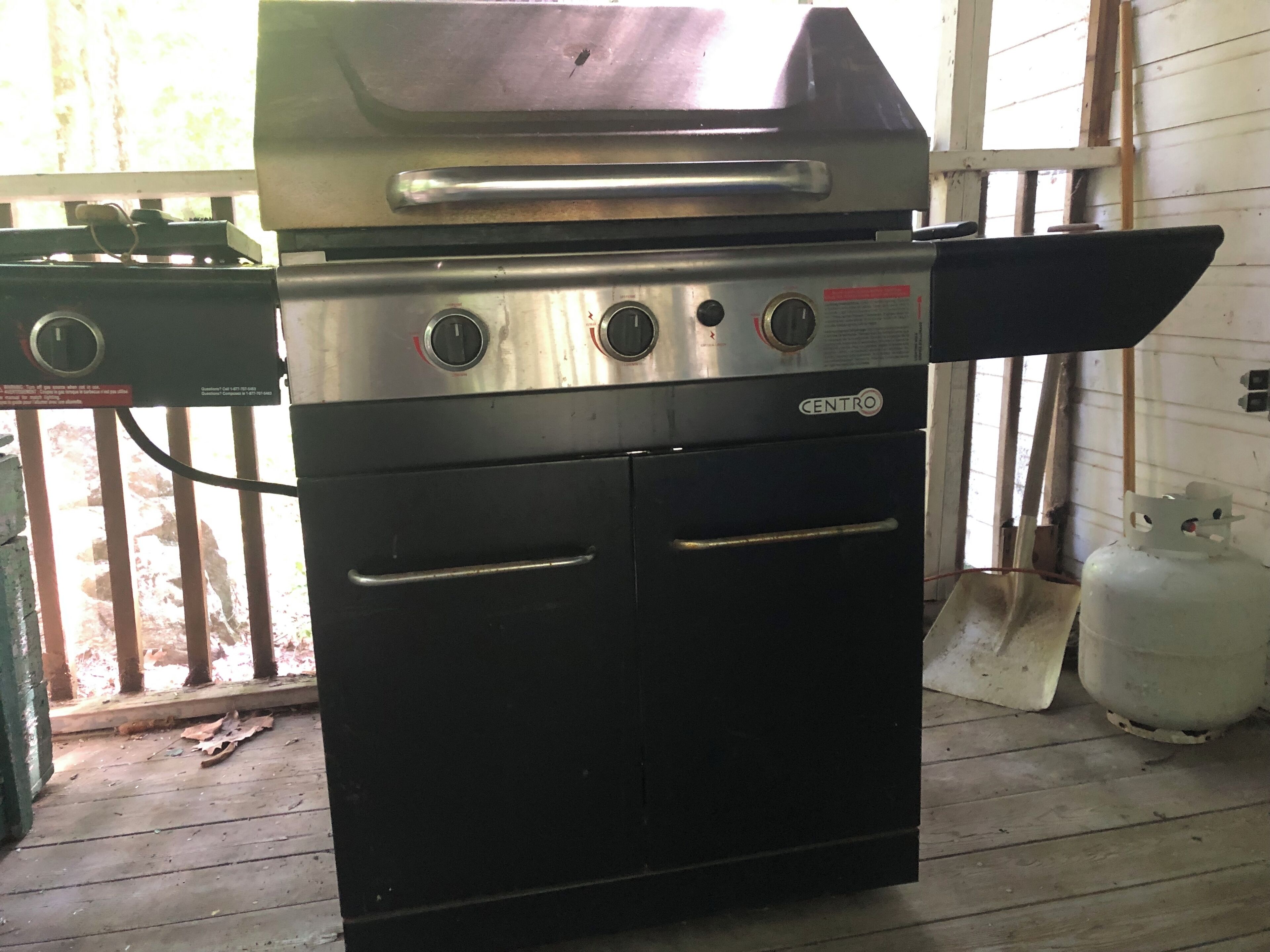A kitchen with a large stove and oven, a gas tank, and a grill.
