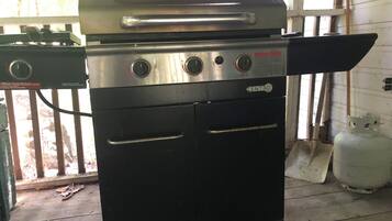 A kitchen with a large stove and oven, a gas tank, and a grill.