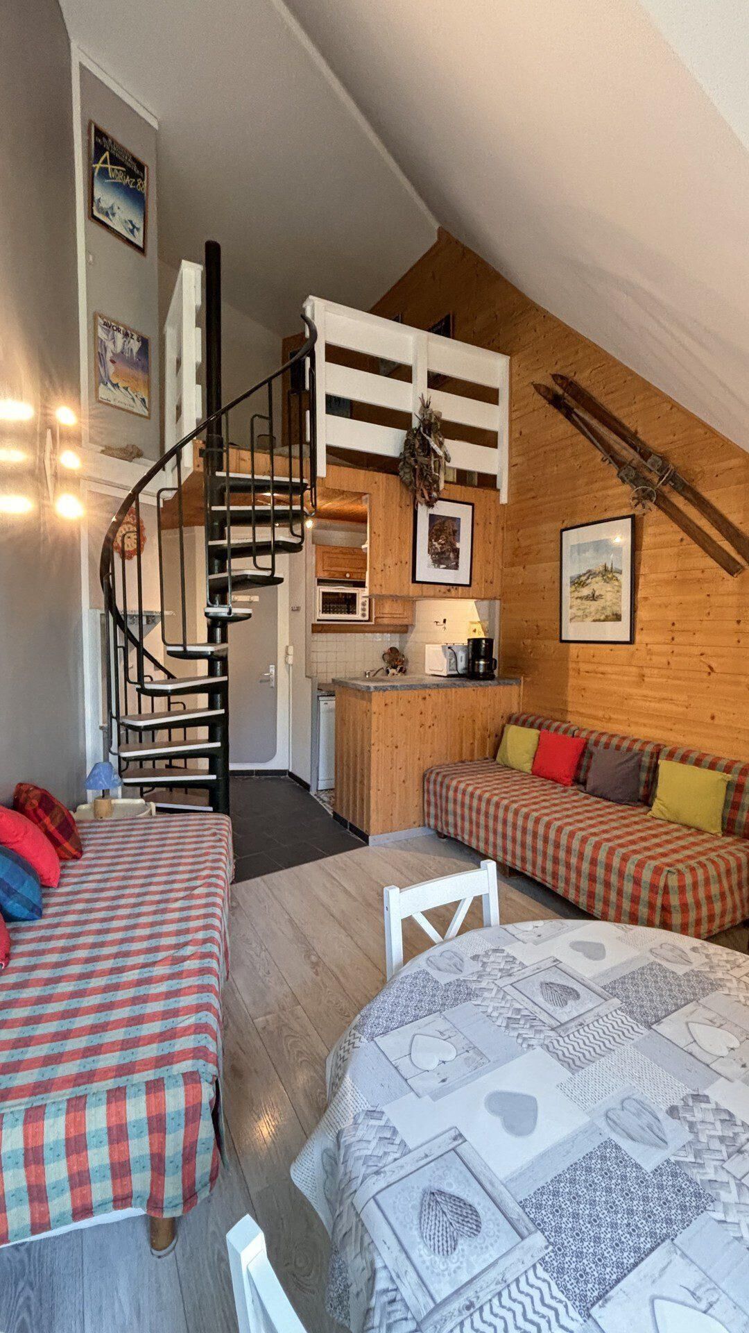 Een gezellig chaletinterieur met een slaaploft, een keuken en een eethoek.
