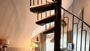Un interior acogedor con una escalera de madera, un comedor y vistas al exterior.