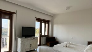 A bedroom with two beds, a television on a white cabinet, and large windows with a view. - Three bedrooms, two bathrooms near St peter's Cathedral Area (Roma)