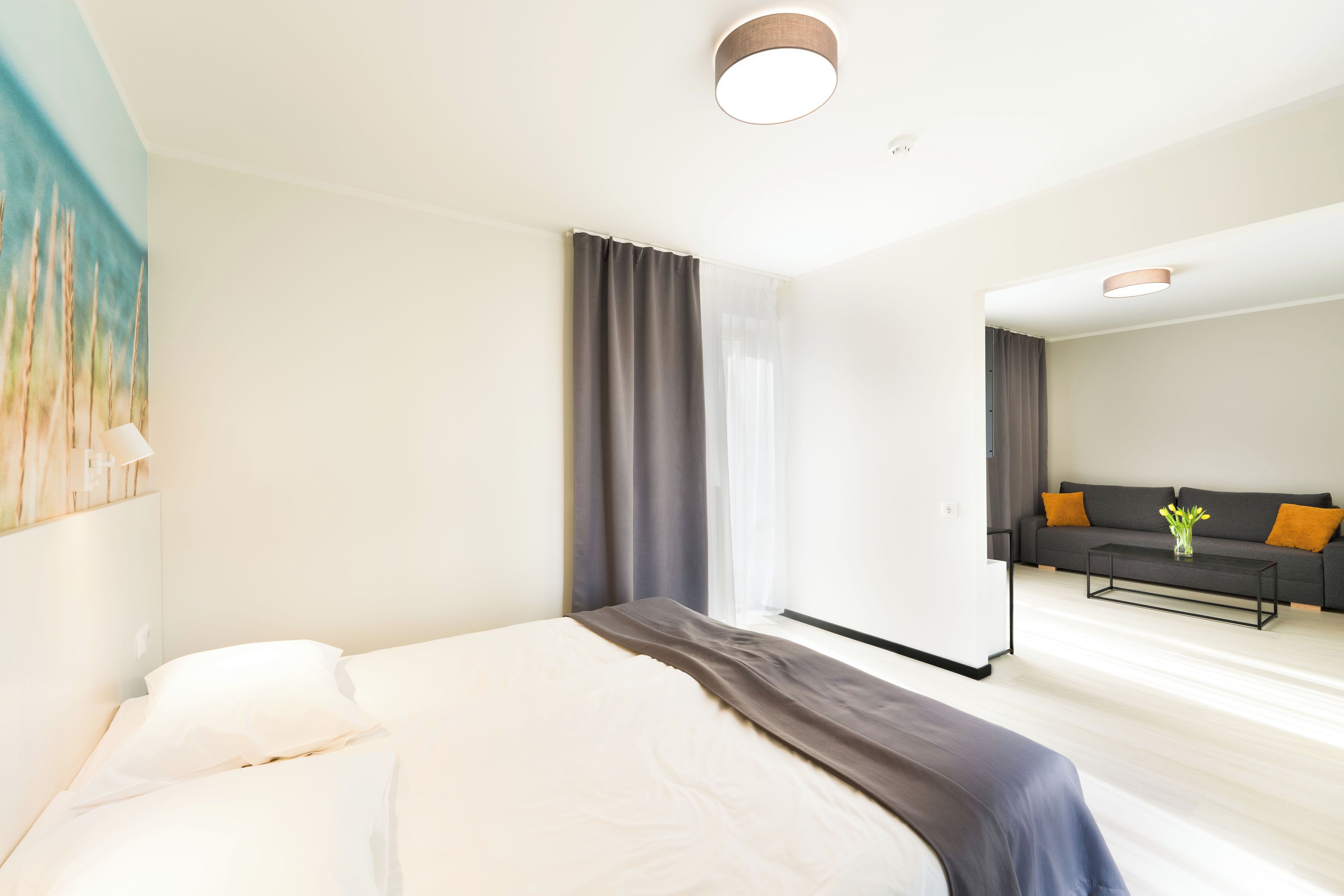 Una habitación de hotel moderna con una cama, un sofá y una mesa de centro.