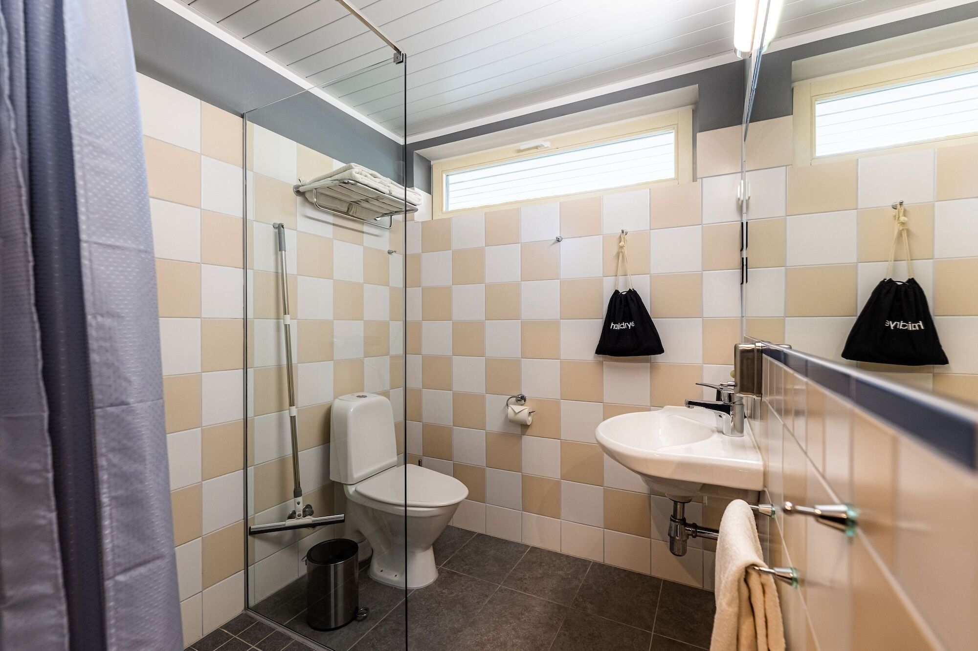 Un baño con inodoro, lavamanos y cabina de ducha de vidrio.
