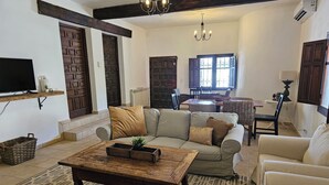 A cozy living room with a sofa, armchairs, a coffee table, and a dining area with a table and chairs. - Villa Finca el Carril, Geweldige Locatie! (Vélez de Benaudalla)