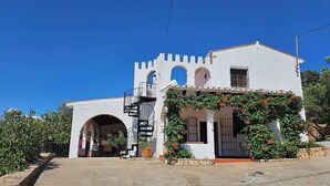 A white building with a tower, arched entrance, and a staircase leading to a balcony. - Villa Finca el Carril, Geweldige Locatie! (Vélez de Benaudalla)