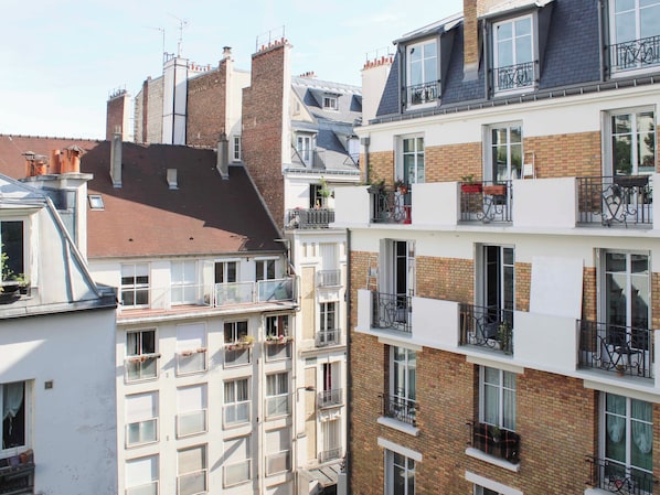A multi-story building with balconies, windows, and brick facades. - Charming 23 m² studio with balcony - Sacré Coeur (Paris)