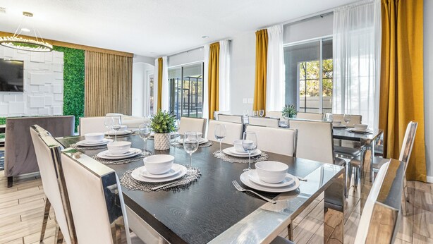 Een moderne eetruimte met een lange tafel voor zes personen, omringd door stoelen.