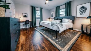 A bedroom with a bed, desk, chair, and a ceiling fan. - The SpokeEasy DownTown Inn (Bentonville)