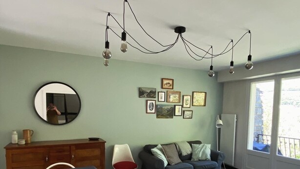 Un salon comprenant un coin repas, un canapé, une table basse et un miroir au mur.