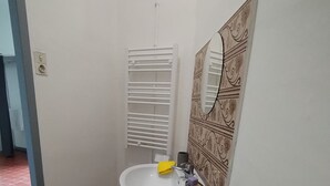 Un bagno piccolo con un lavandino bianco, un water e un porta asciugamani.
