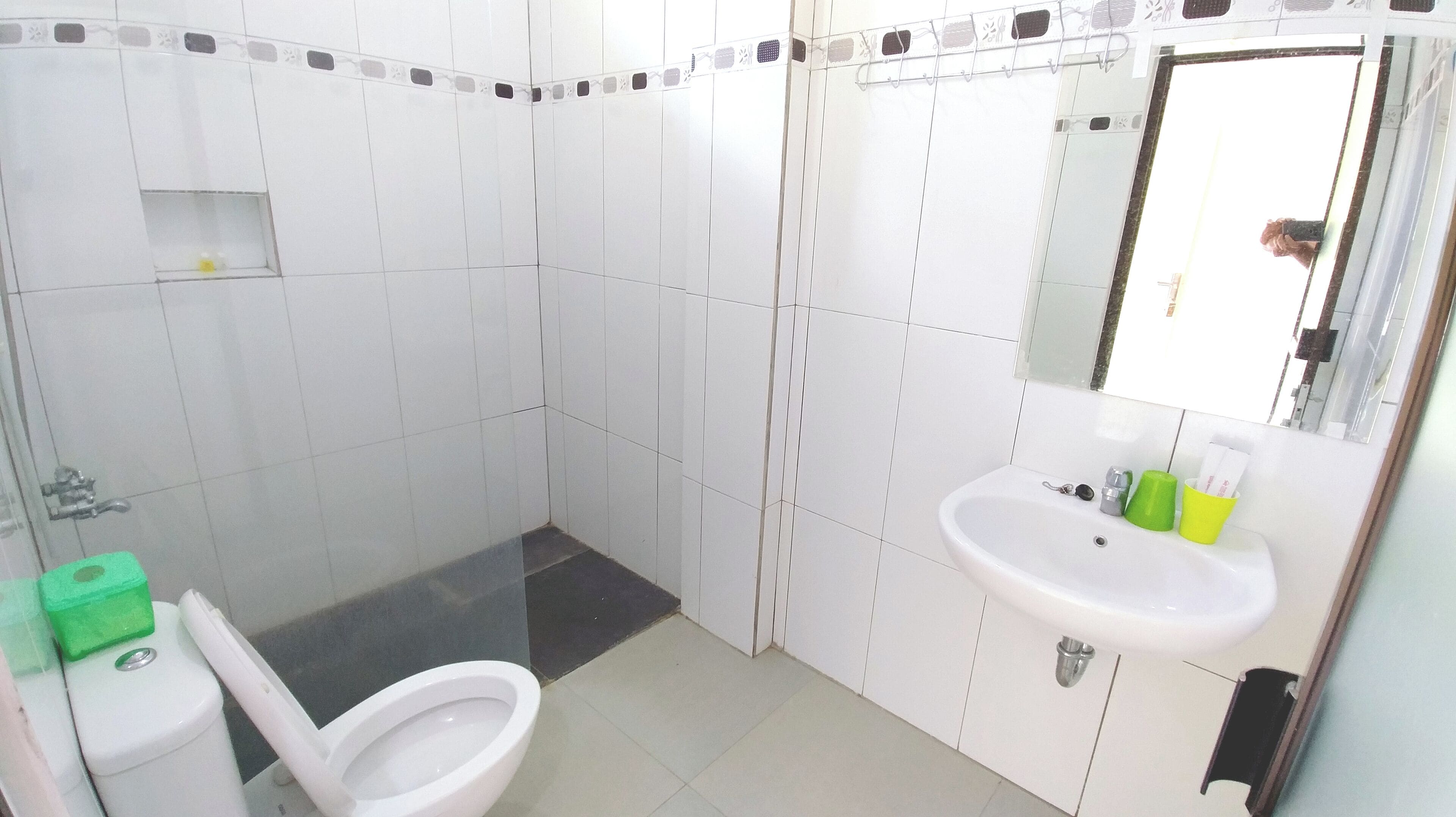 Un baño con inodoro, lavabo y espejo.
