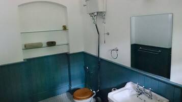 A bathroom with a toilet, sink, and mirror.
