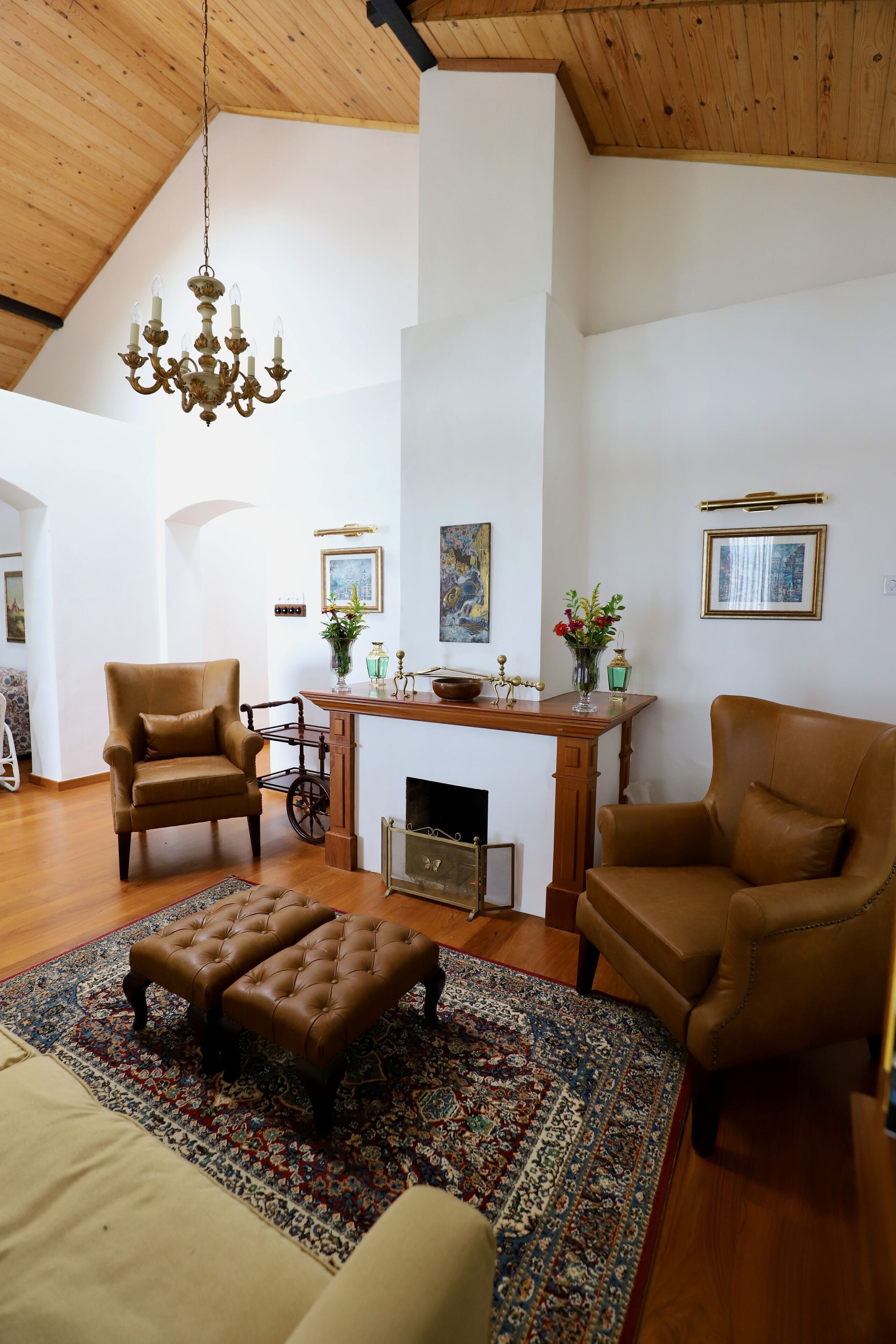 Un salón amplio con techo alto, chimenea y un gran tapete.