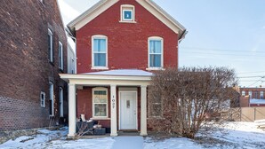 A red brick house with a white door and two windows, number 1037. - Cheerful home by Millwork District/Farmers Market (Dubuque)
