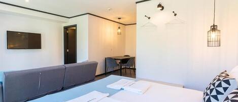 Une chambre d’hôtel moderne équipée d’un lit, d’un canapé, d’un bureau et d’une télévision.