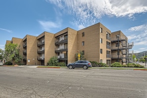 A multi-story apartment building with a parking lot in front.