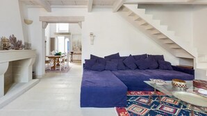 A modern living room with a large blue sectional sofa, a fireplace, and a staircase. - Garibaldi Luxury, in complete luxury and relaxation (Otranto)