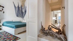A bedroom with a bed, a colorful rug, and a wall-mounted hammock. - Garibaldi Luxury, in complete luxury and relaxation (Otranto)