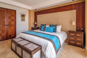 A hotel room with a large bed, a wooden wardrobe, a bedside table with a lamp, and a decorative mirror on the wall. - Curamoria Collection Celeste Huatulco (Santa María Huatulco)