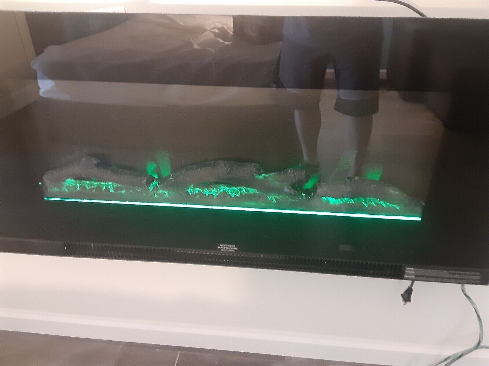 A large aquarium with a green light strip at the bottom.