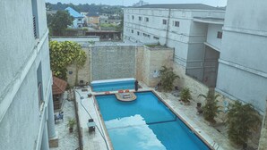 A rooftop swimming pool with a view of surrounding buildings. - Fullmoon Hotels Owerri (Owerri)