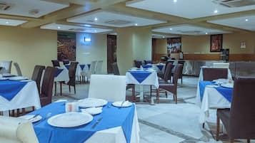 Un comedor con mesas dispuestas para varias personas, con una distribución limpia y ordenada.