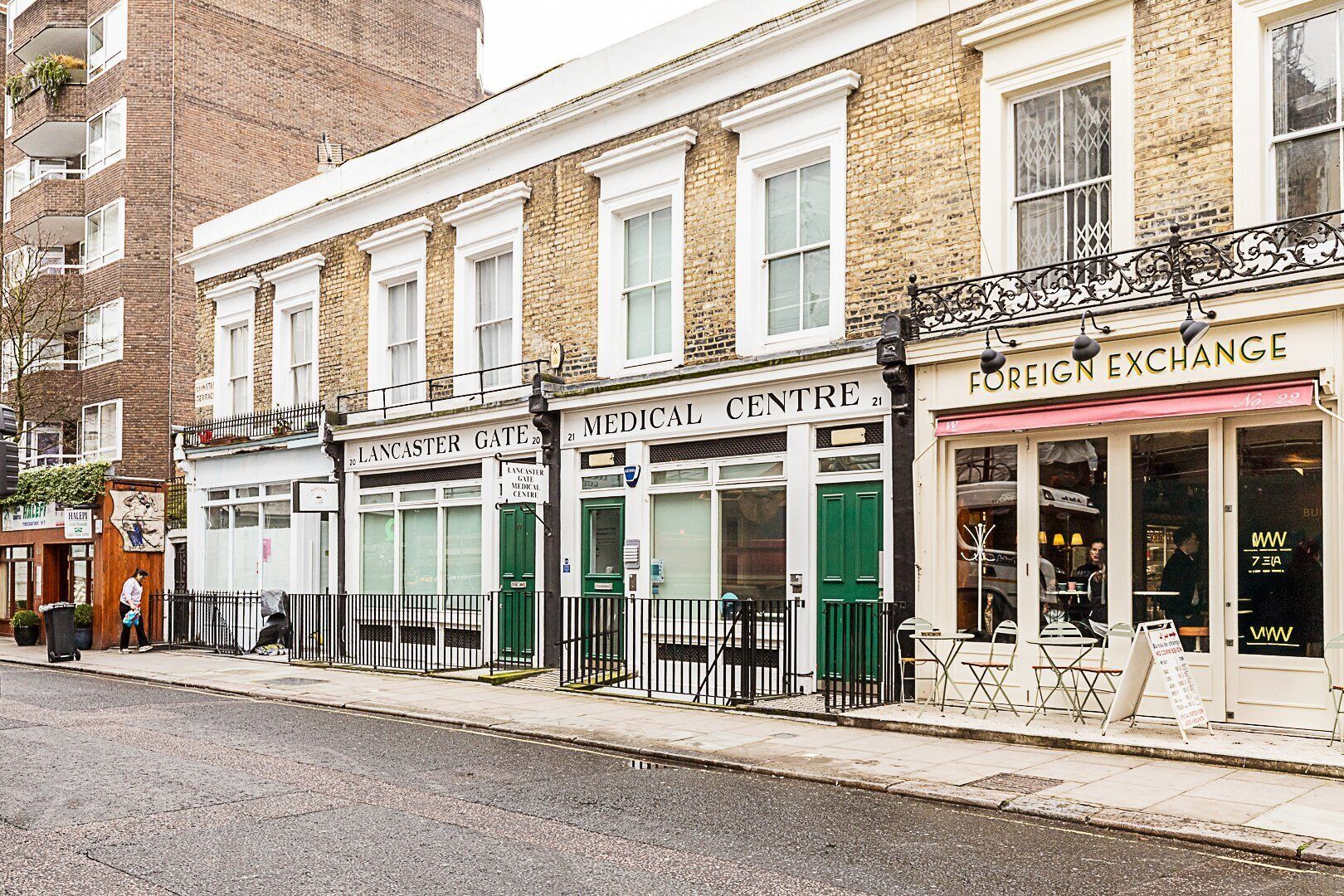 A row of buildings with storefronts including a medical center and a foreign exchange.