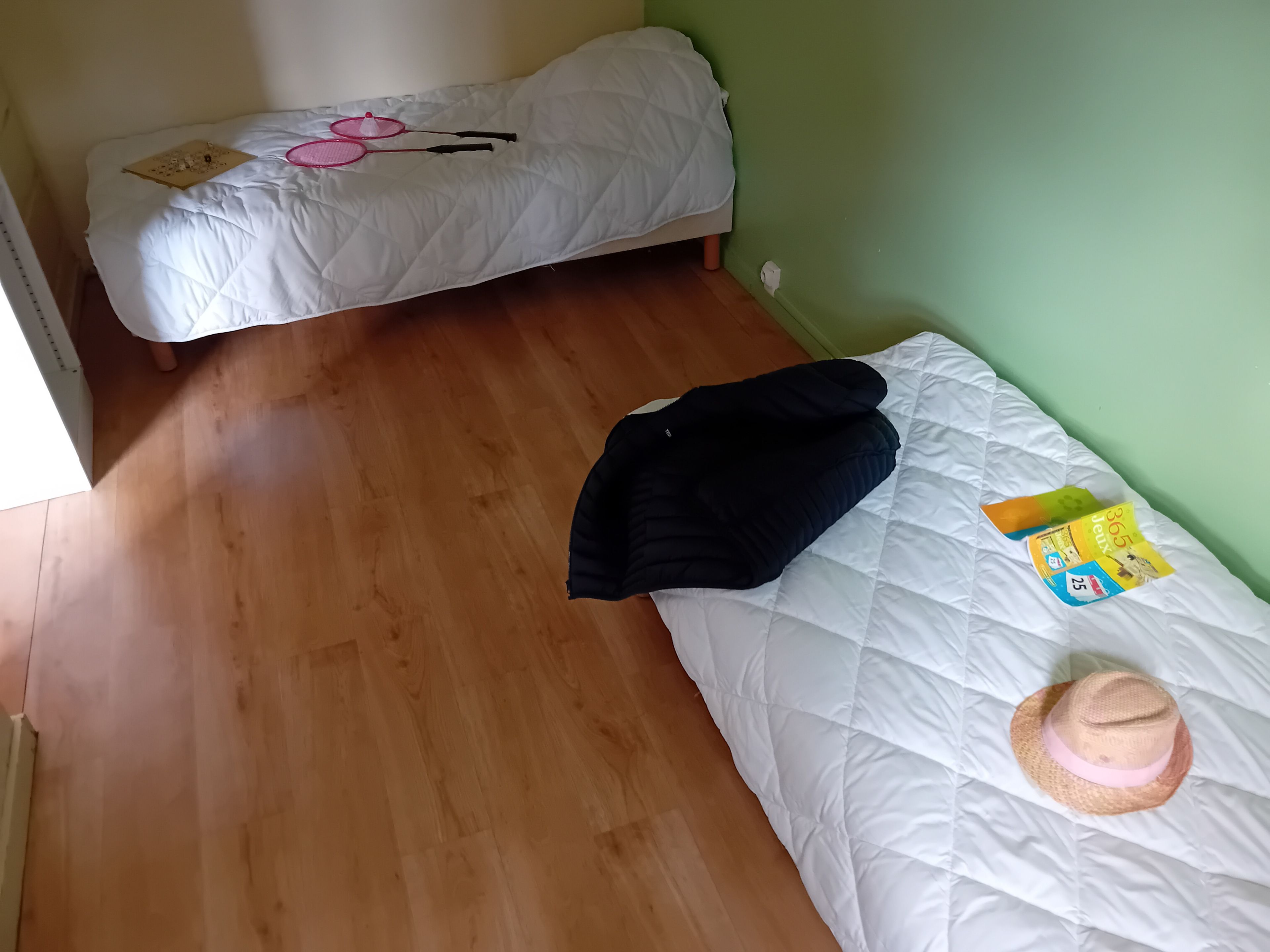 A room with a bed, a small table, and a wall socket.