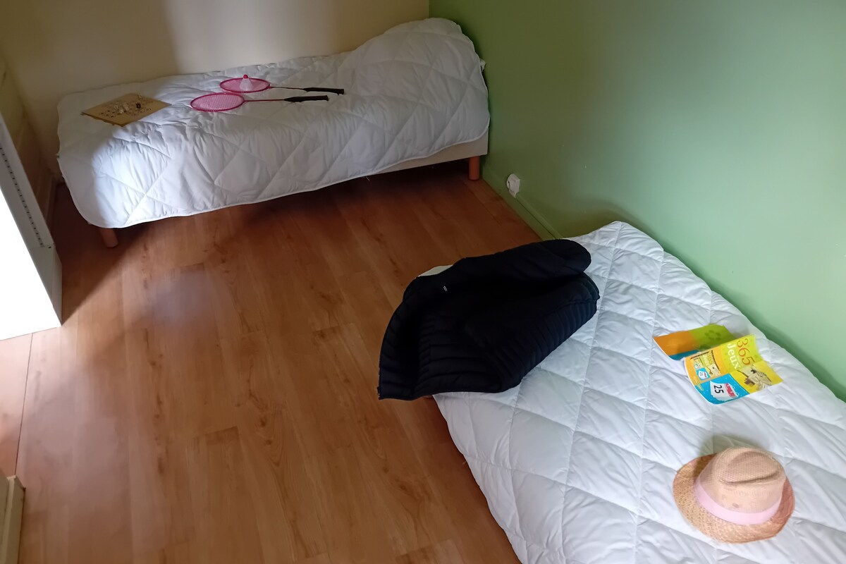 Et værelse med en seng, et lille bord og en stikkontakt.
