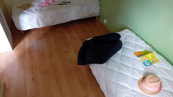 A room with a bed, a small table, and a wall socket.