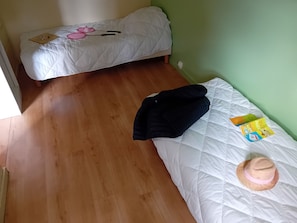 Una habitación con una cama, una mesita y un enchufe.