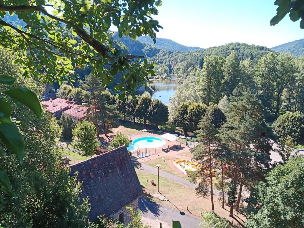 A view of a swimming pool surrounded by trees and a mountain backdrop.