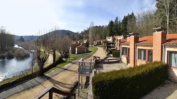 A riverside property with multiple buildings, a pathway, and a wooden bench.