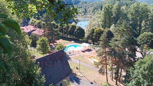 Vista di una piscina circondata da alberi con una montagna sullo sfondo.