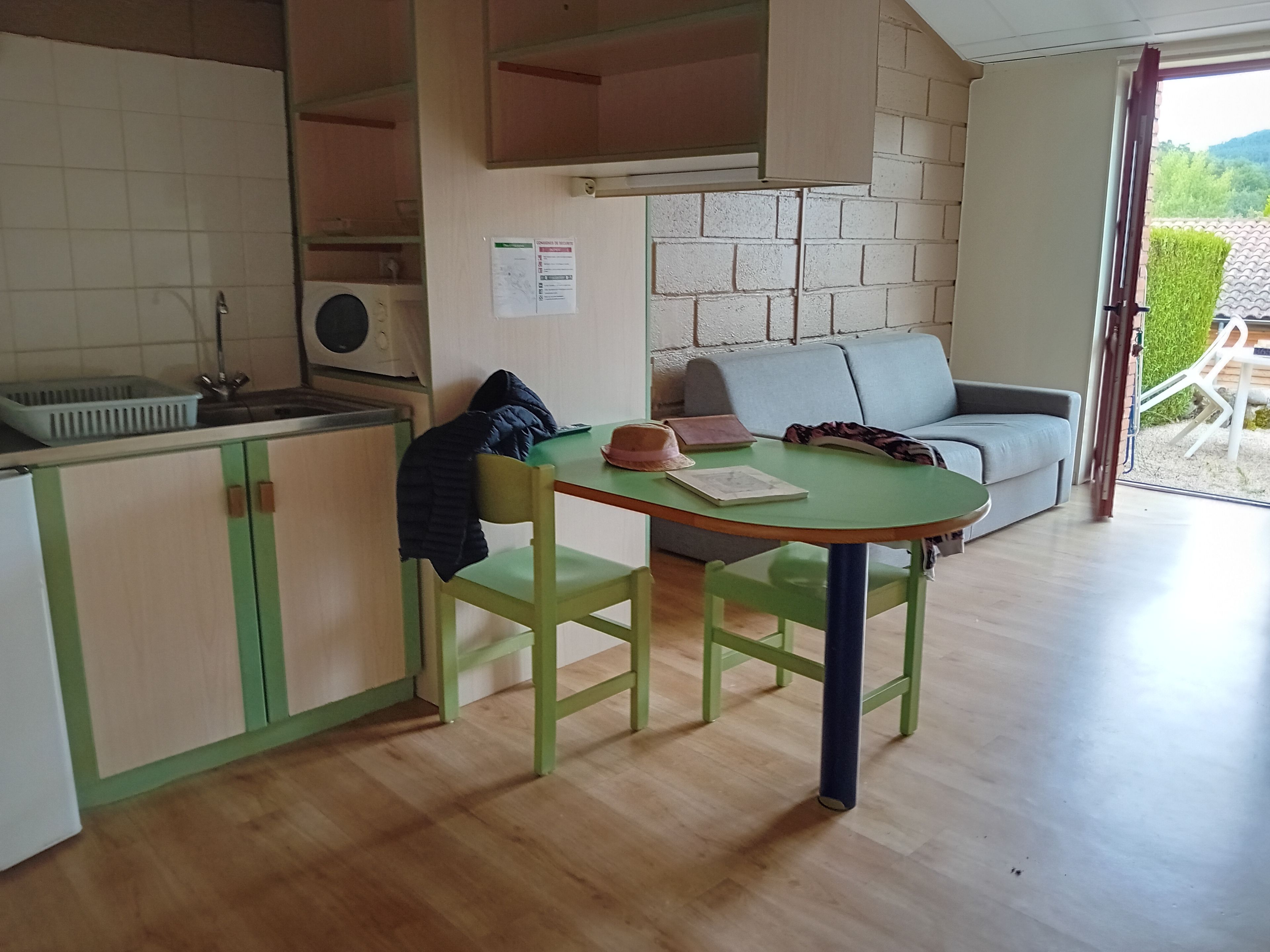 A compact living space with a kitchenette, a dining table, and a sofa.