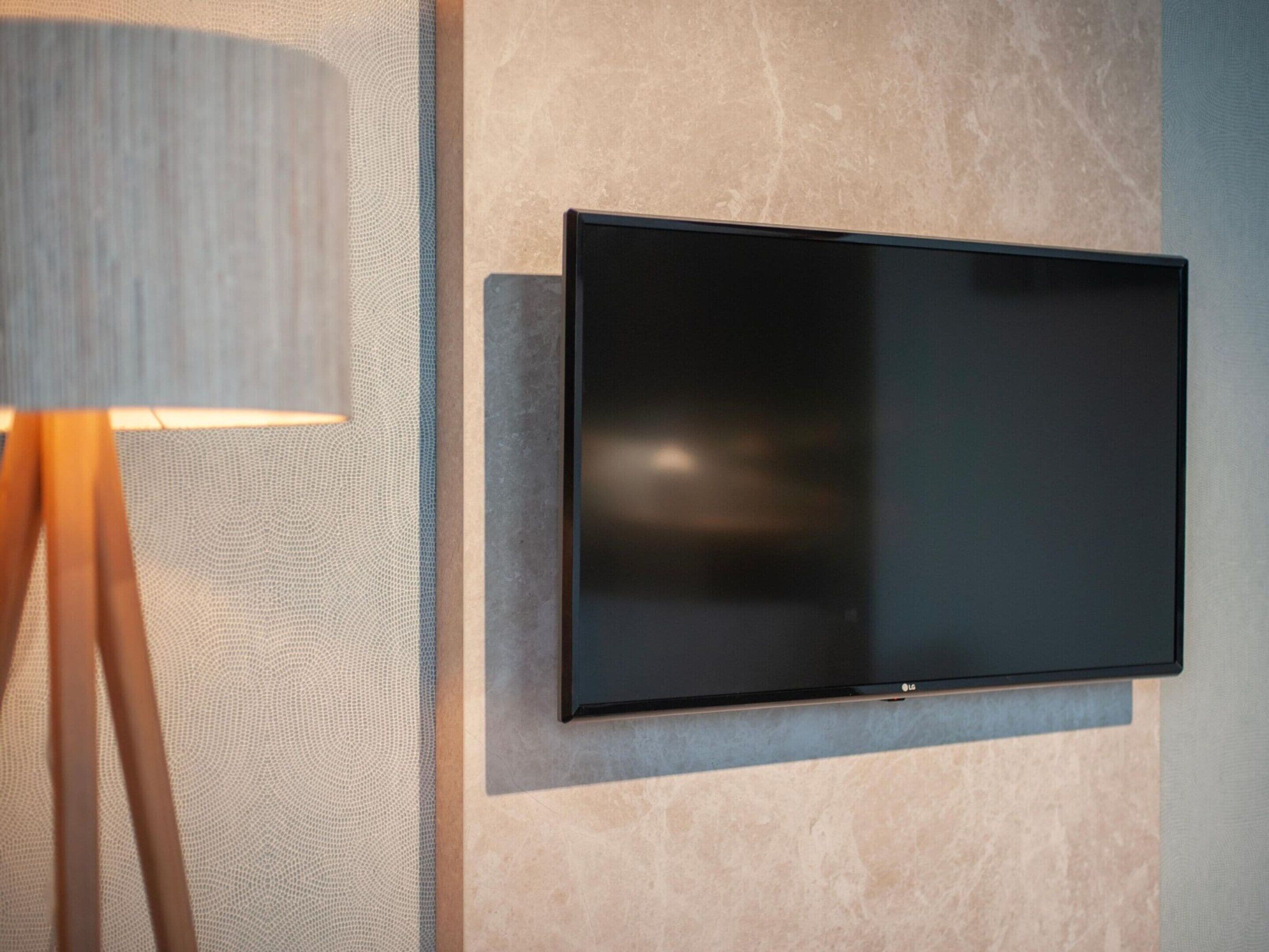 Ein Flachbildfernseher an einer strukturierten Wand befestigt.
