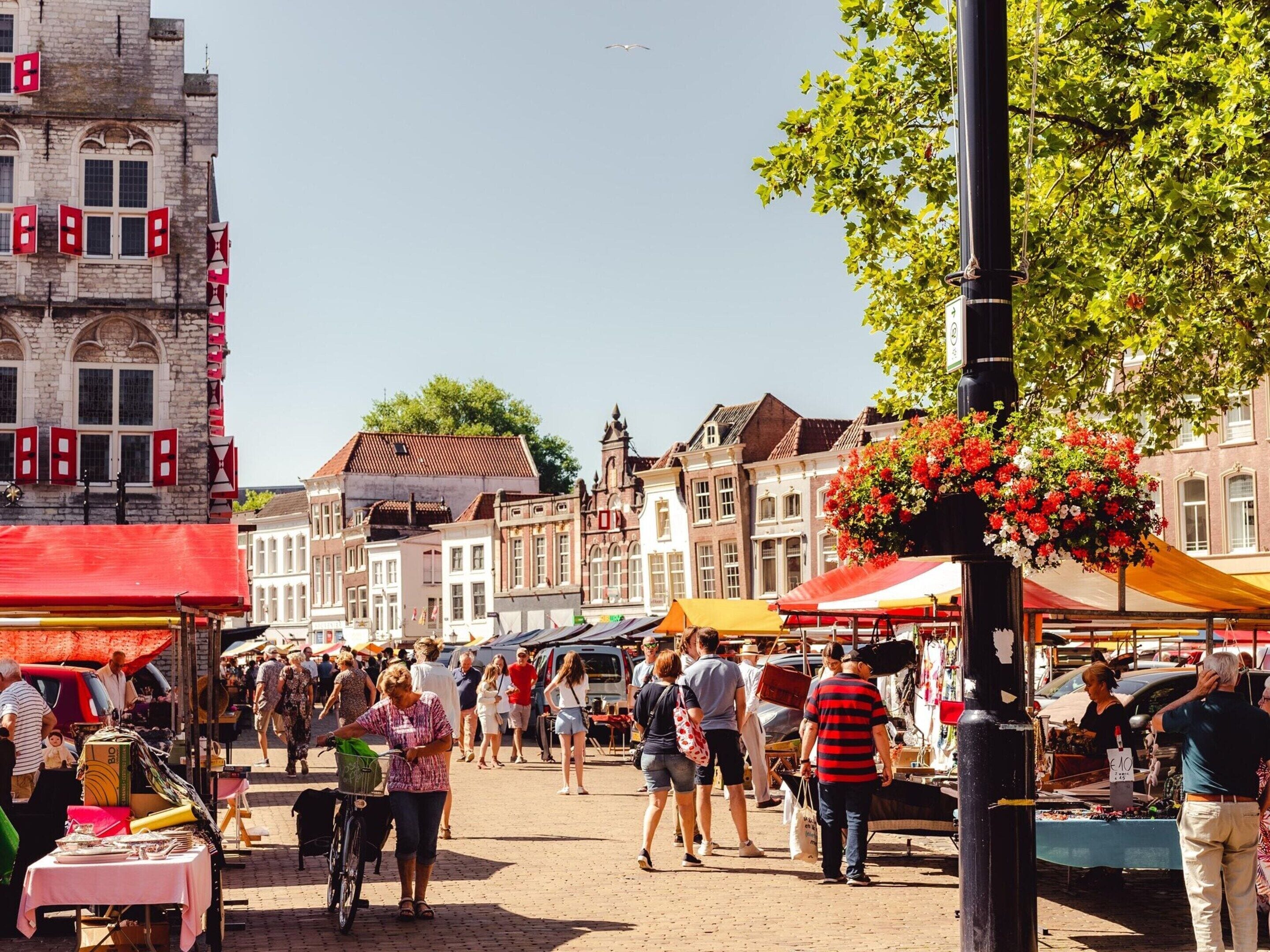 Een levendige openbare markt met verschillende kraampjes en mensen die er rondlopen.