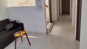Ein Flur mit Treppe, einer Couch und einem kleinen Tisch mit einer Kiste.
