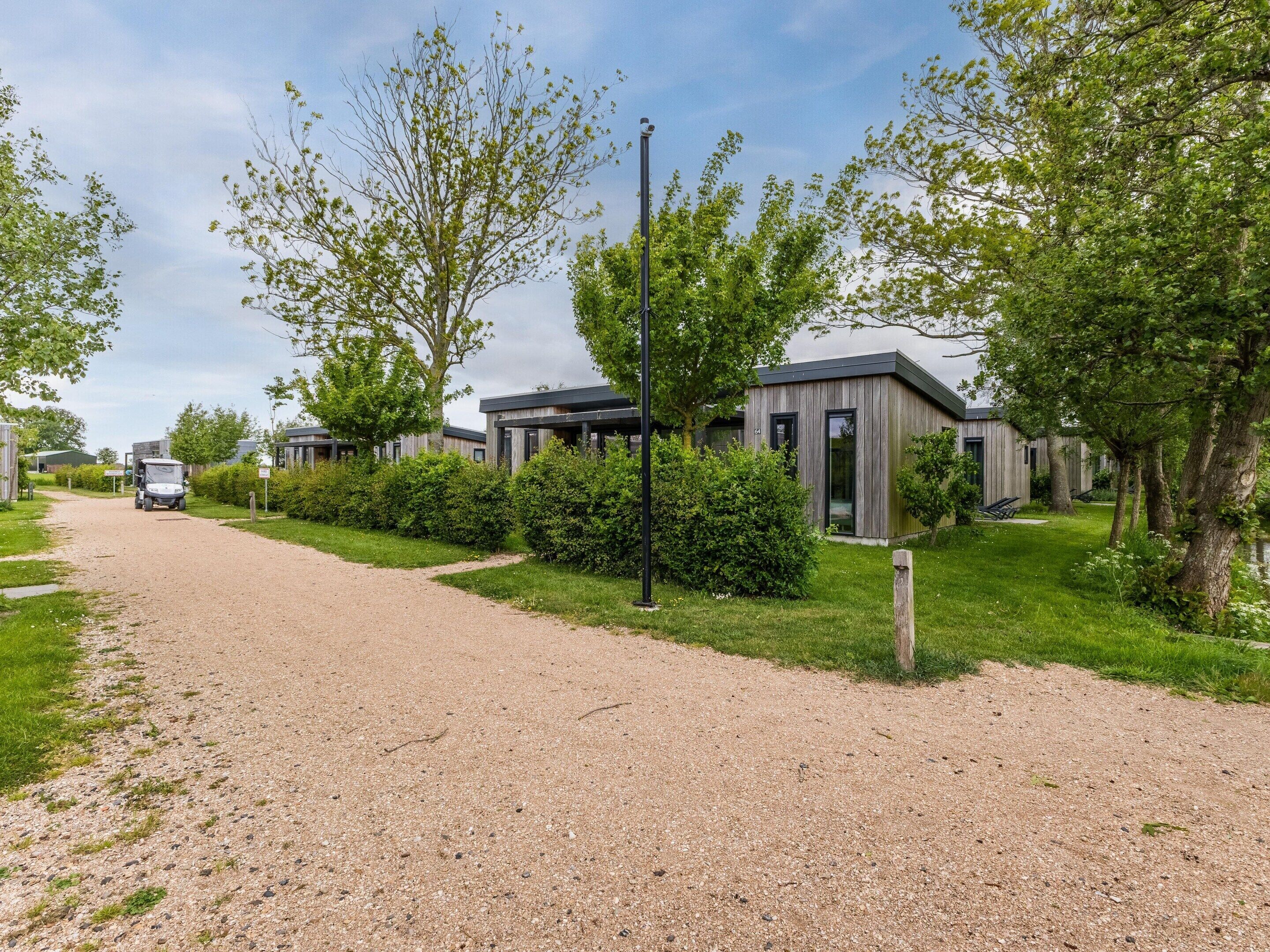A gravel driveway leading to modern mobile homes with a clear sky.
