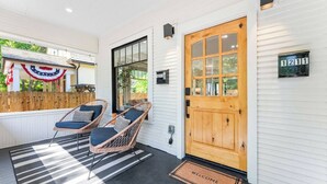 A porch with two wicker chairs, a wooden door, and a mailbox. - * The Bungalow at Hyde Park * (Boise)
