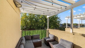 Ein überdachter Außenbereich mit Korbmöbeln und einer Pergola.