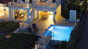 A two-story house with a swimming pool, outdoor seating, and a balcony. - Villa Julia with a private heated pool, ideal for large groups (Milna)