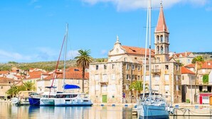 A coastal town with a prominent church and a bell tower, boats docked at the harbor, and a backdrop of residential buildings. - Villa Julia with a private heated pool, ideal for large groups (Milna)