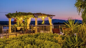 A garden area with a pergola, seating, and a view of the landscape. - Villa Julia with a private heated pool, ideal for large groups (Milna)