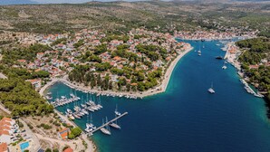 An aerial view of a coastal town with a marina, houses, and hilly terrain in the background. - Villa Julia with a private heated pool, ideal for large groups (Milna)