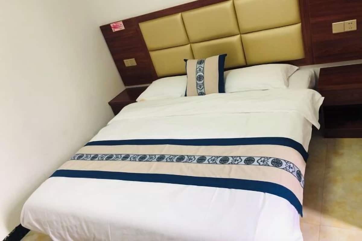 Ein Hotelzimmer mit einem Bett, einem Kopfteil und einem Nachttisch.