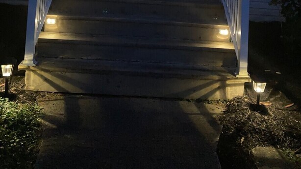 Een trap die naar de ingang van een huis leidt, met een deur en ramen.