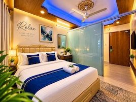 Habitación de hotel moderna con una cama grande, ventilador de techo y una pared con una cita motivacional.
